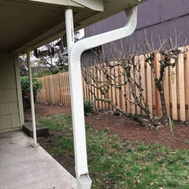 3x4 corrugated downspout installation with curved design showing proper water drainage system and professional white aluminum gutter solution