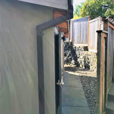 Royal Gutters' modern black downspout installation with sleek wall mounting - professional Portland craftsmanship. Call 503-558-8700