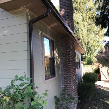Beaver brown K-style gutter seamlessly installed on mixed-material home with brick and light siding, complementing natural surroundings in Portland