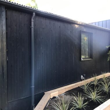 Royal Gutters' black round downspout with half-round gutter - modern design for contemporary Portland homes. Call 503-558-8700