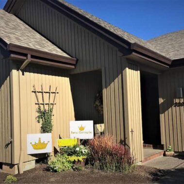 Beaver brown box-bottom gutters with square downspouts installed on craftsman-style home, matching vertical siding for seamless integration