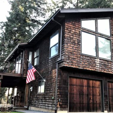 Tuxedo gray gutters on craftsman home with cedar shake siding, perfectly matching architectural style while providing efficient water management