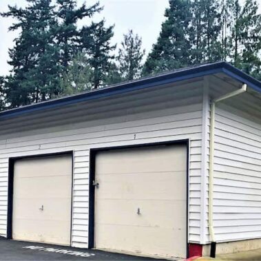 Custom blue gutter and downspout installation on white garage, showing perfect color matching and professional installation by Royal Gutters Portland