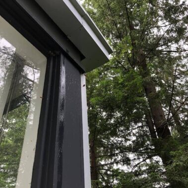 Royal Gutters seamless corner installation with black aluminum gutters and white trim, Portland home protection