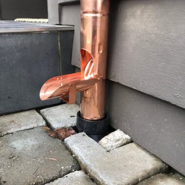 Copper gutter cleanout installation showing easy-access maintenance point for efficient debris removal and gutter cleaning in Portland homes