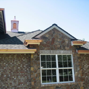 Premium Copper K-Style Gutter installation by Royal Gutters Portland - architectural detail on luxury stone home with custom copper accents