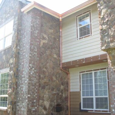 Custom copper K-Style gutter with corrugated downspout by Royal Gutters Portland - expert installation on mixed-facade home. Call 503-558-8700