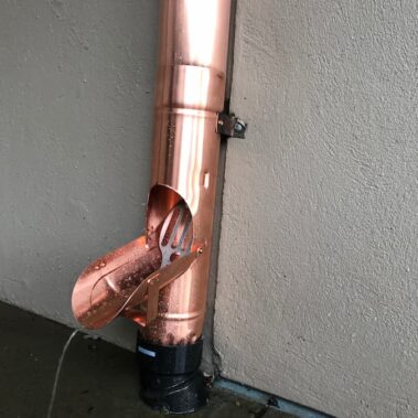 Copper round downspout cleanout installation by Royal Gutters, showcasing professional maintenance access point and quality material durability