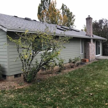 Colonial blue gutter system professionally installed on two-story white siding home, featuring multi-level drainage and architectural integration