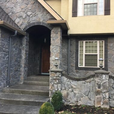 Royal Gutters' custom fascia gutter installation on Portland luxury stone home. Seamless integration, expert craftsmanship. 503-558-8700