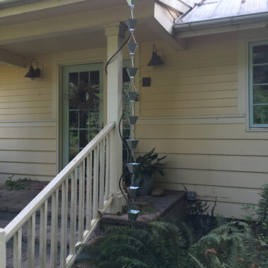 Royal Gutters' galvanized half-round gutter with decorative rain chain installation in Portland. Professional water management solution. 503-558-8700