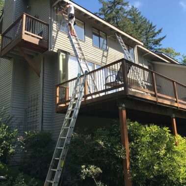 Royal Gutters expert safely installing gutters on multi-story Portland home. Professional service for complex projects. Call 503-558-8700