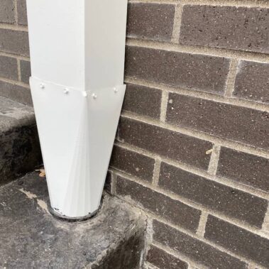 Royal Gutters' precision-installed white square downspout - seamless drainage connection on brick exterior. Expert Portland installation: 503-558-8700