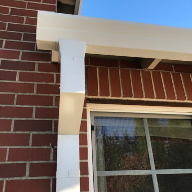 Royal Gutters' white square downspout with Max Flow outlet - seamless fascia integration on brick building. Portland experts: 503-558-8700