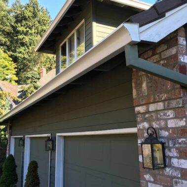Royal Gutters' white Spanish curved gutters with custom-painted downspouts, enhancing Portland home aesthetics. Expert installation. 503-558-8700